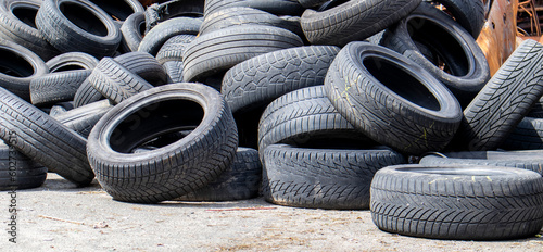 Industrial dump for the processing of used tires and rubber tires. Pile of old tires and wheels for rubber recycling. Tire dump. Recycling of used tires. Produced reclaimed tire rubber.