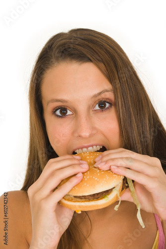Caucasian woman eating a hambuger on a white background