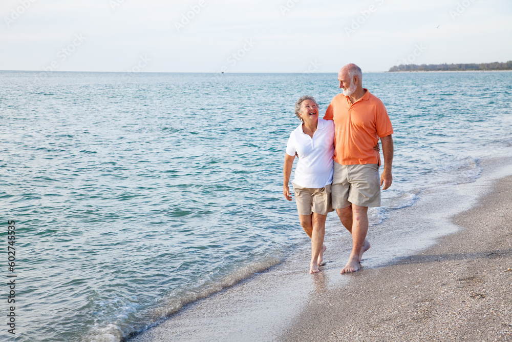 Beautiful senior couple takes a romantic stroll on a tropical beach.