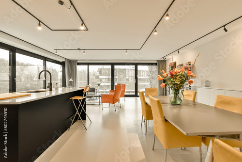 a kitchen and dining area in a modern home with white walls, flooring and black trim on the ceiling