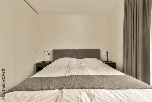 a bed in a room with curtains on either sides and the headboards up against each other one's wall