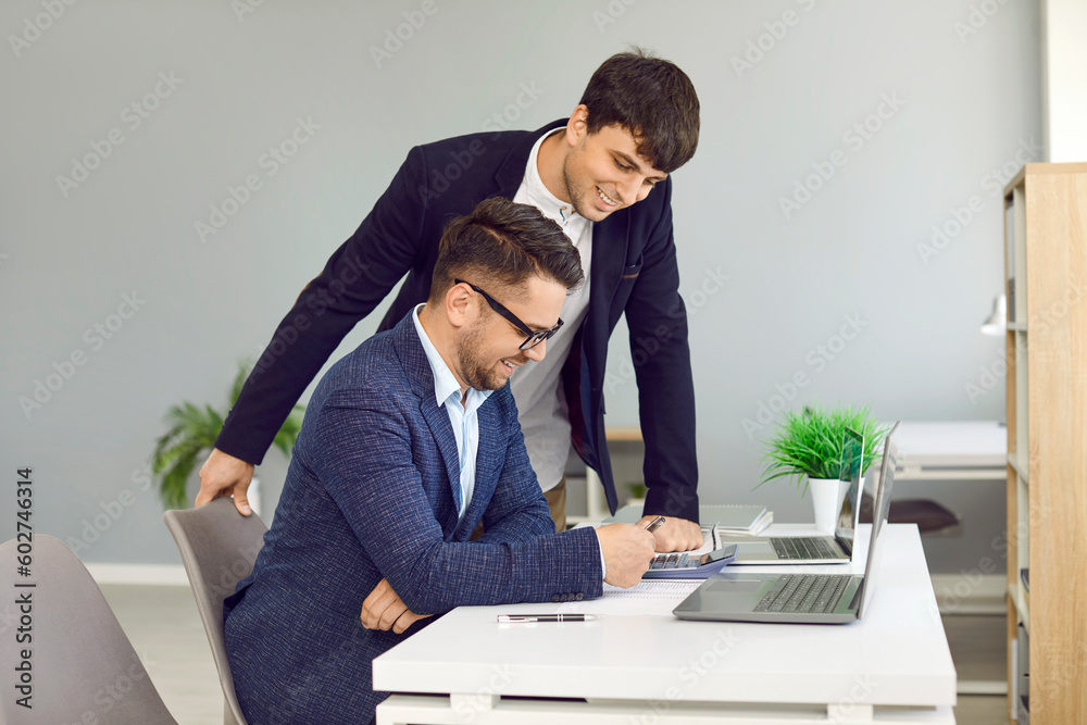 © Studio Romantic - Two business colleagues analyzing strategy discussing financial planning schedule and company budget. Smiling men with calculator calculate financial statements together in office. © Studio Romantic - Two business colleagues analyzing strategy discussing financial planning schedule and company budget. Smiling men with calculator calculate financial statements together in office.