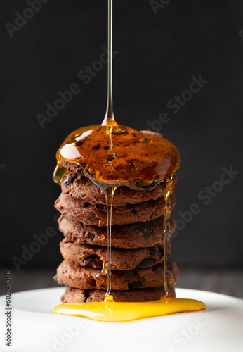 Homemade cookies sprinkled with honey on a dark background.