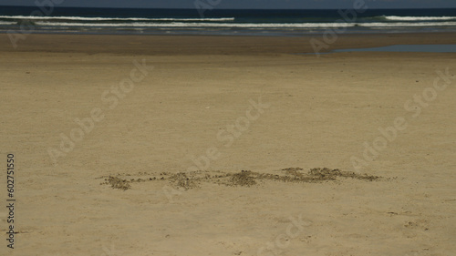 Palavra Praia escrito na areia da praia de rivieira de são lourenço em bertioga SP Brasil.  photo