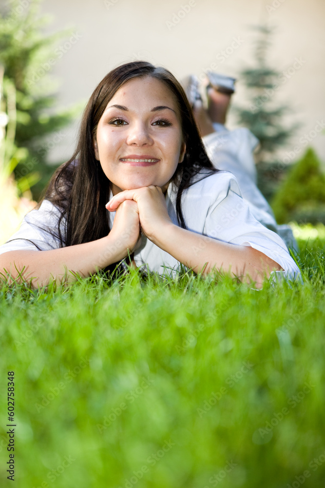 attractive brunette woman lying on grass attractive brunette woman lying on grass