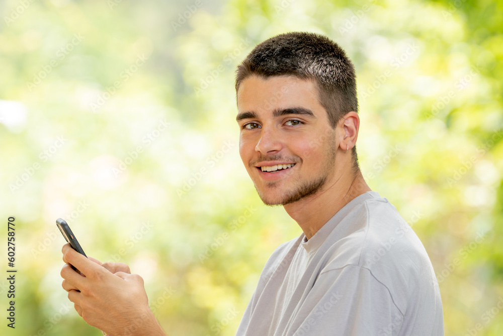 young man with mobile or cell phone outdoors