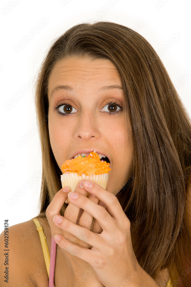 Caucasian woman eating a chocolate cupcake on a white background Caucasian woman eating a chocolate cupcake on a white background