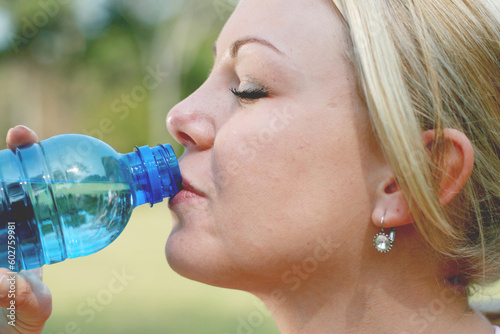 blond woman drink water after fitness workout