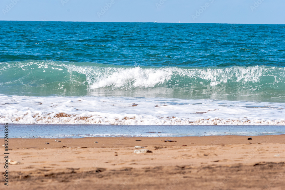 Sopelana beach near Bilbao. Contrast with the golden sand and the blue of the ocean. Big Waves crashing creating white foam that vaporises in the air.