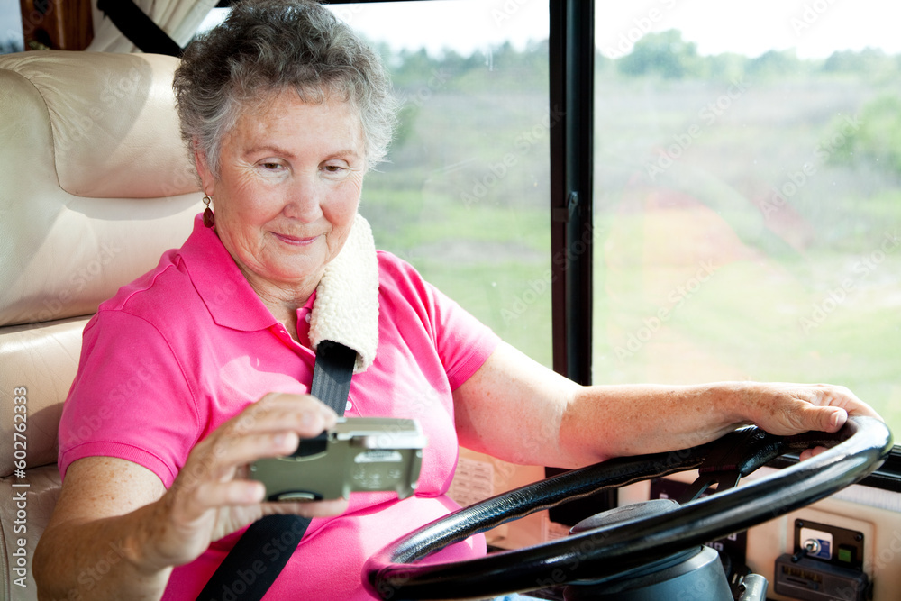 Senior woman using a GPS to navigate while driving her motor home. Senior woman using a GPS to navigate while driving her motor home.