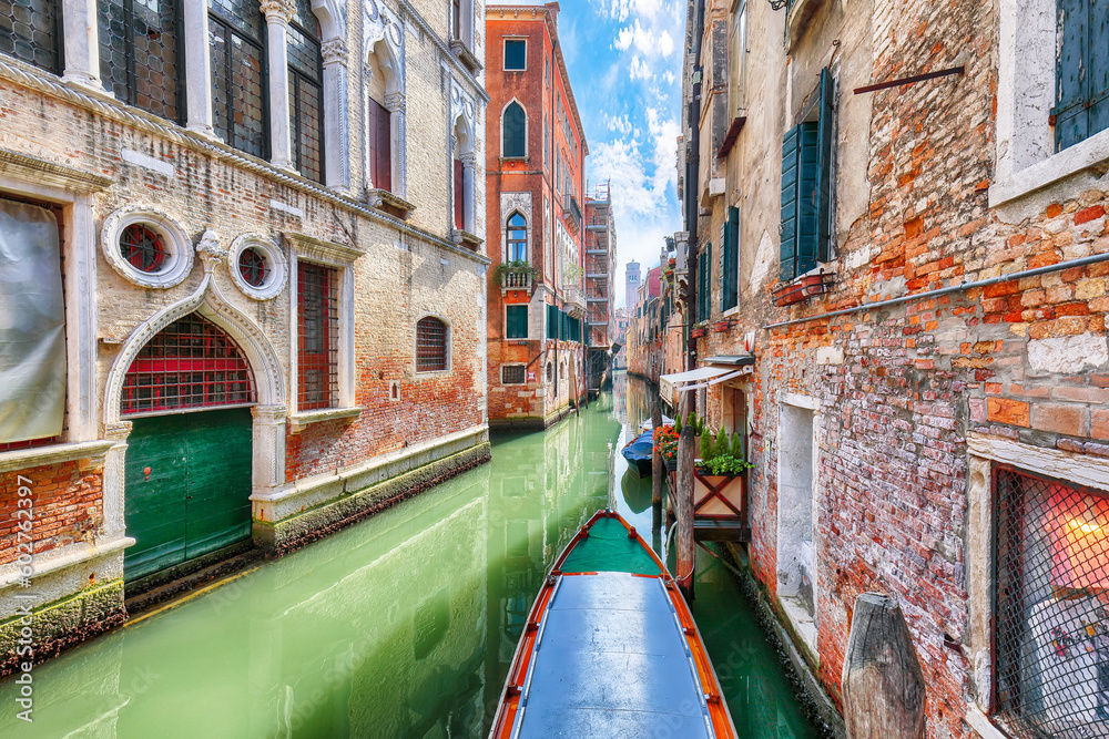 Fabulous cityscape of Venice with narrow canals, boats and gondolas and bridges with traditional buildings