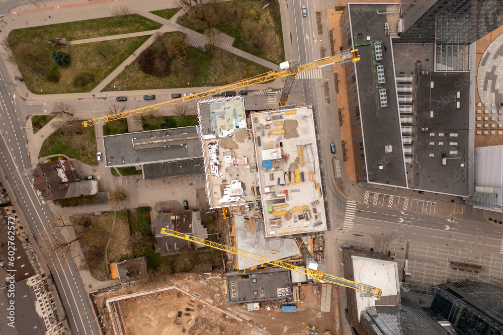Drone photography of urban construction site of skyscraper complex in the middle of other structures during spring sunny day Drone photography of urban construction site of skyscraper complex in the middle of other structures during spring sunny day