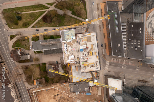 Drone photography of urban construction site of skyscraper complex in the middle of other structures during spring sunny day
