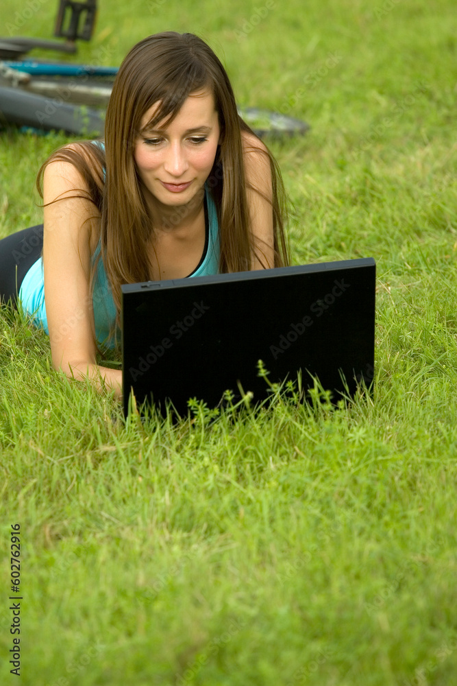 female student with laptop relaxing on the grass female student with laptop relaxing on the grass