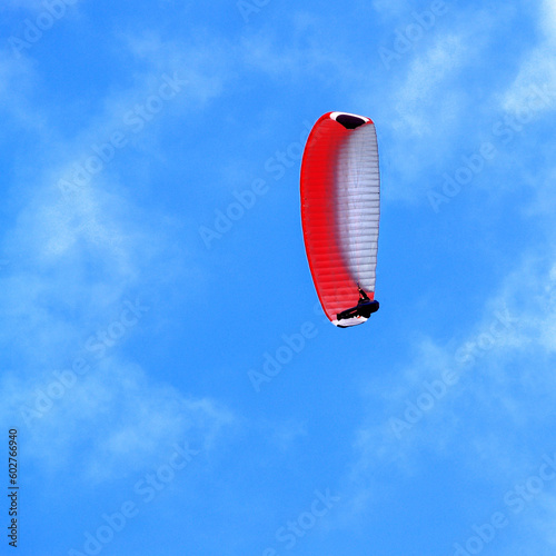 man, hovering in the sky by parachute