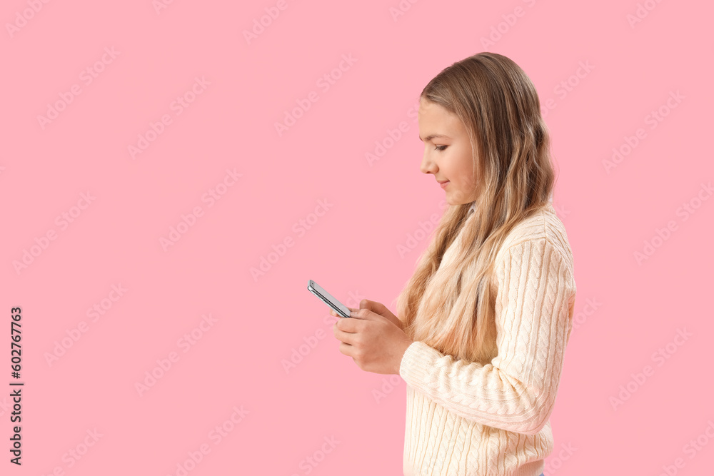Little girl using mobile phone on pink background Little girl using mobile phone on pink background