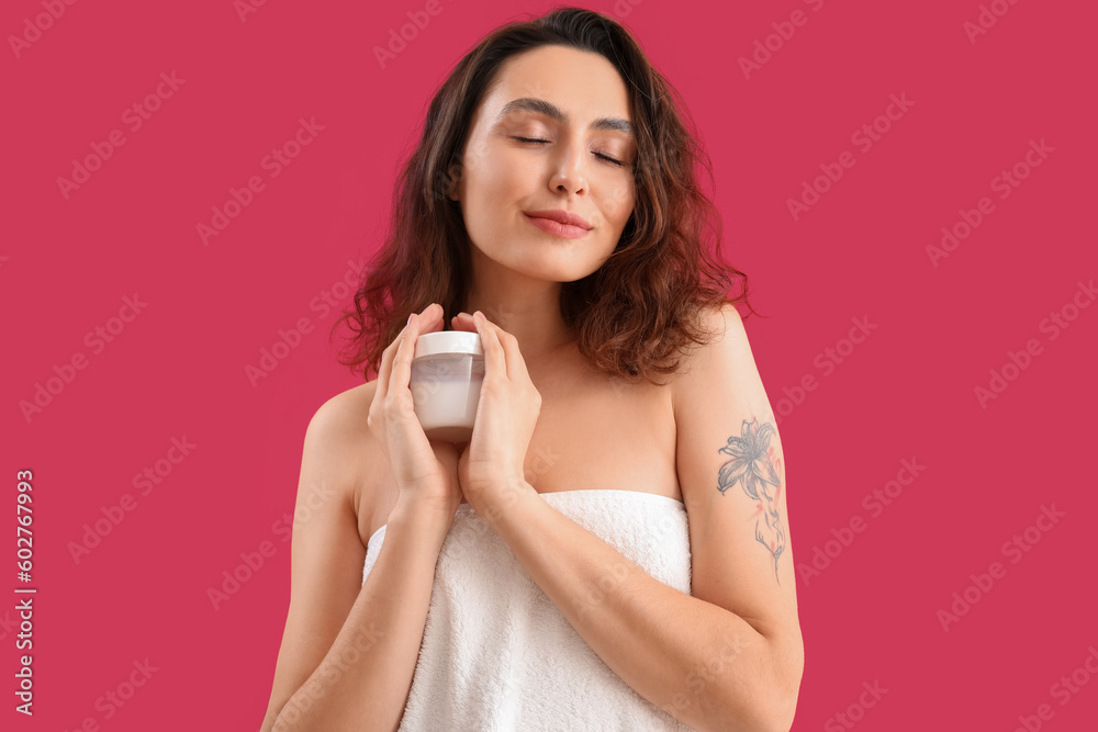Young brunette woman with jar of cosmetic cream on pink background Young brunette woman with jar of cosmetic cream on pink background