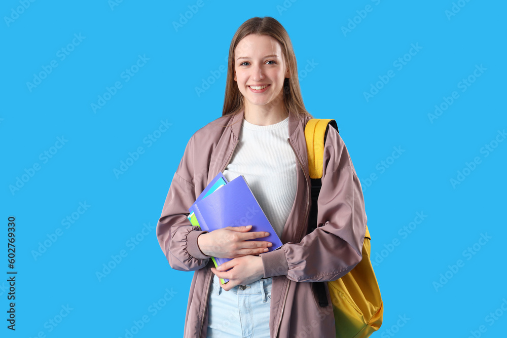 Female student with copybooks on blue background Female student with copybooks on blue background