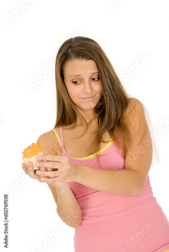 Caucasian woman eating a chocolate cupcake on a white background