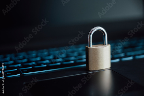 A golden padlock placed on laptop computer keyboard