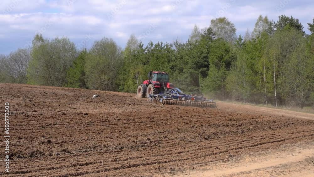 Tractor on the farmer's field plows and cultivates the soil. Agriculture, farming business harvest concept. High quality FullHD footage Tractor on the farmer's field plows and cultivates the soil. Agriculture, farming business harvest concept. High quality FullHD footage