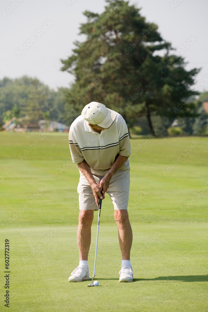 Obraz premium Elderly Man Playing Golf at the Golf Course