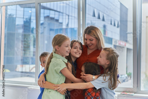 A child hugging a teacher in a modern kindergarten