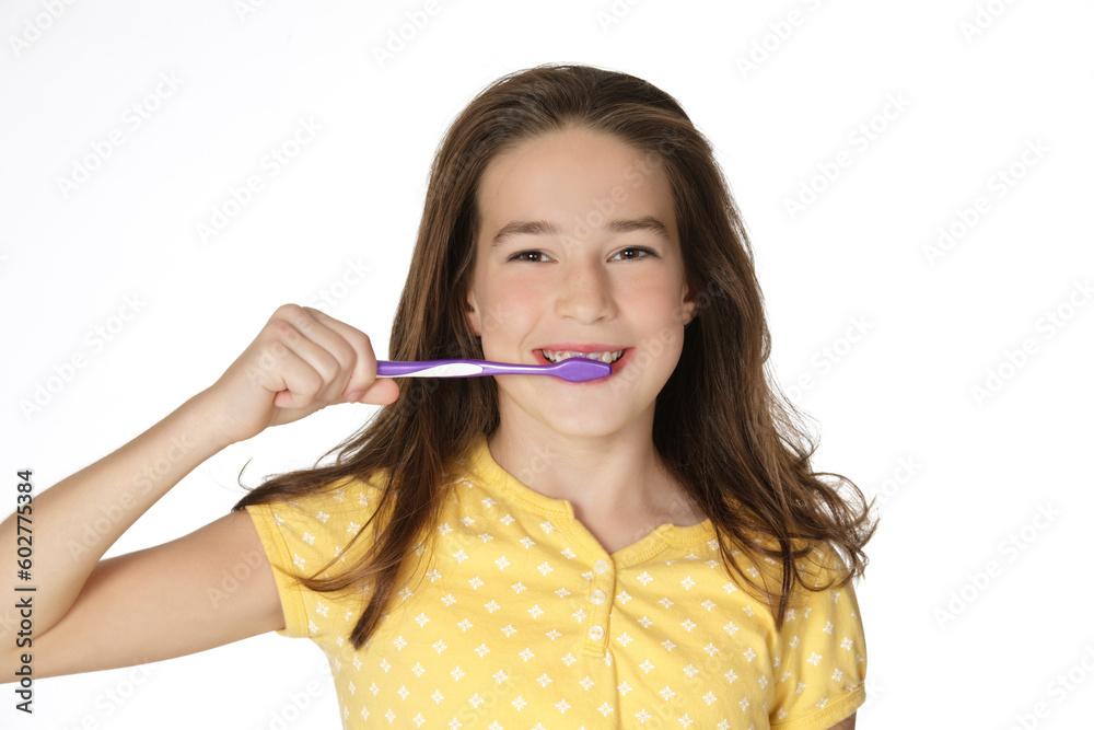 Cute Caucasion girl brushing her teeth isolated on a white background Cute Caucasion girl brushing her teeth isolated on a white background