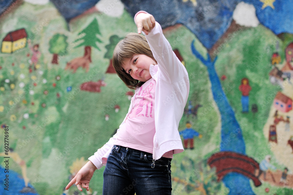 Fototapeta premium happy young girl posing and jumping with abstract urban style painting bacground begind