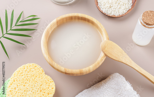 Homemade cosmetic rice water with ingredients on beige background, healthy beauty treatment ingredients for homemade comsetics, beauty recipe for home spa, natural skincare preparation, close up photo