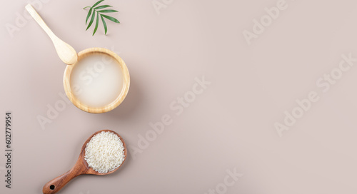 Homemade cosmetic rice water with ingredients on beige background, healthy beauty hair treatment ingredients for homemade comsetics, beauty recipe for home spa, natural skincare preparation, top view