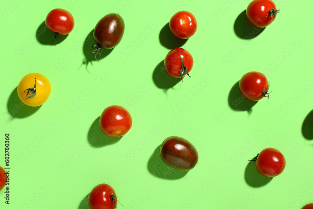 Different fresh cherry tomatoes on green background Different fresh cherry tomatoes on green background