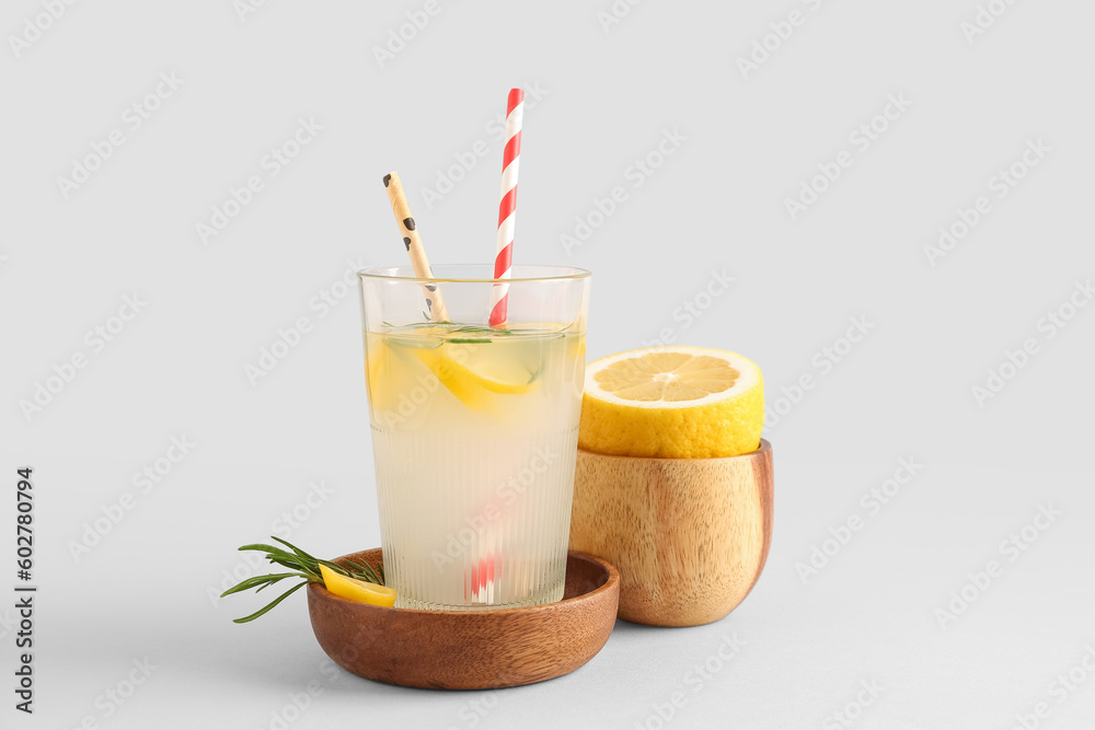 Bowl and glass with fresh lemonade on grey background Bowl and glass with fresh lemonade on grey background