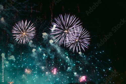 Obraz na płótnie Blue white and green fireworks celebration in the sky. Very cheap firework over the city, Blue white and green w salonie