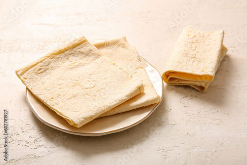 Plate with fresh lavash on light background photo