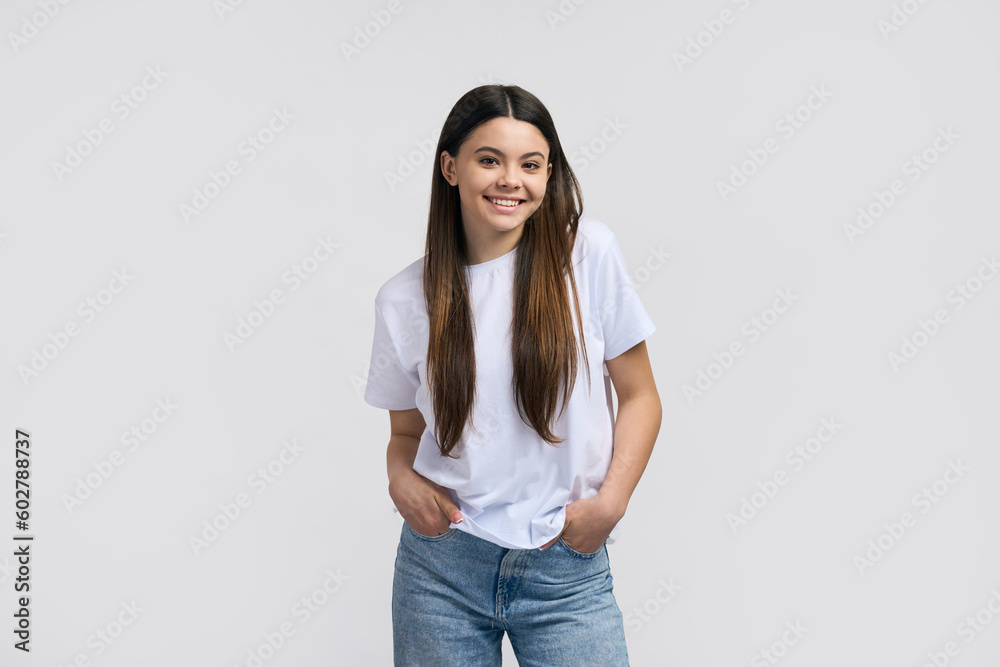 Laughing cheerful teen girl in casual white T-shirt and blue jeans, smiling cutely, looking at camera Laughing cheerful teen girl in casual white T-shirt and blue jeans, smiling cutely, looking at camera
