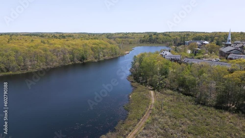 4K drone video featuring a serene lake and an elegant church steeple. The aerial view captures the calm waters reflecting the majestic steeple