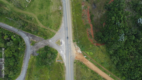 Visão aérea de uma rodovia, com veículos em movimento e paisagens ao redor, em um dia claro e iluminado photo