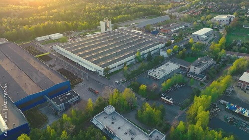 An industrial giant glows in the warmth of the setting sun. The aerial shot captures the magnitude of the building, surrounded by smaller structures.