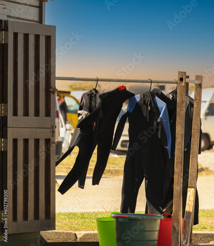 hut with wetsuits hung up to dry to be used for surfing on the beach