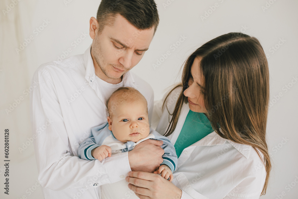 Happy family of mother, father and baby boy, wearing casual clothes on white background. Happy family of mother, father and baby boy, wearing casual clothes on white background.