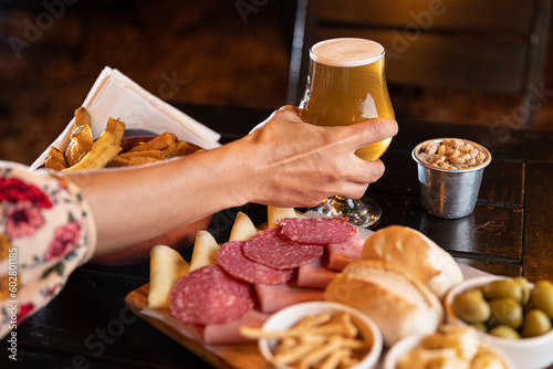 food plate with chips salami and cheese with glasses of beer
