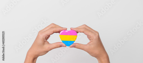 Pansexual Pride Day and LGBT pride month concept. hand holding pink, yellow and blue heart shape for Lesbian, Gay, Bisexual, Transgender, Queer and Pansexual community