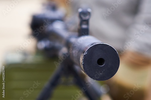 The muzzle of a weapon close-up. The barrel of a machine gun at an arms exhibition. The concept of aggression and the threat of death. Selective focus.