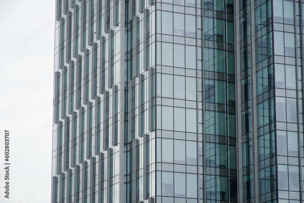 Transparent glass facade of a modern blue-green skyscraper. Windows and walls. Construction background. Copy space. Transparent glass facade of a modern blue-green skyscraper. Windows and walls. Construction background. Copy space.