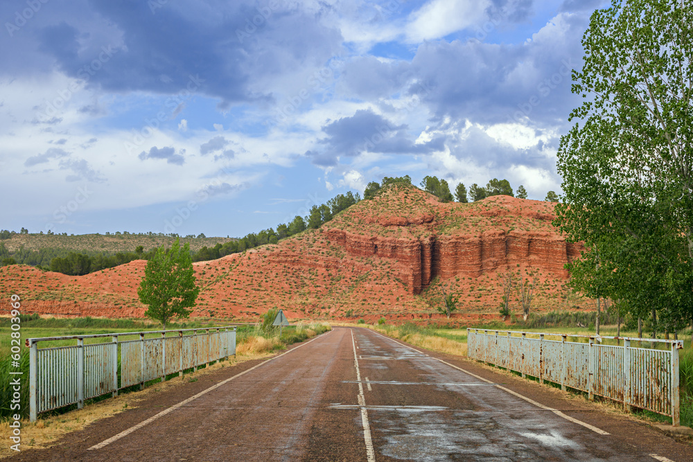 Fototapeta premium A landscape between red limestone mountains with a two-way road