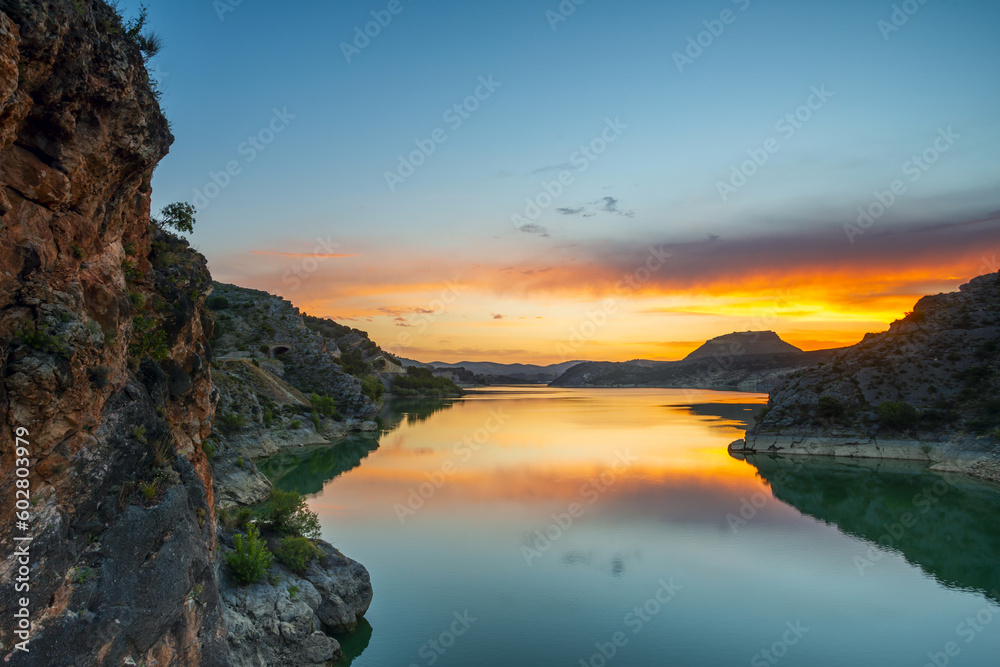 Views of a lake between mountains at sunset