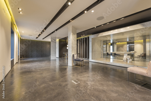An empty retail space with polished concrete floors and ceiling lighting fixtures