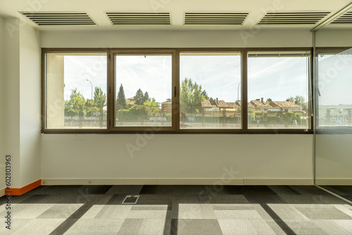 empty offices with separate offices with glass partitions  large windows with unobstructed views of other buildings