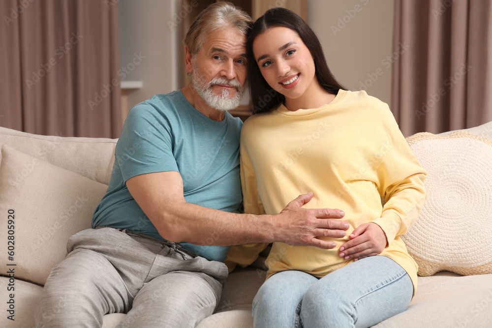 Father and his pregnant daughter indoors. Grandparents' reaction to future grandson Father and his pregnant daughter indoors. Grandparents' reaction to future grandson